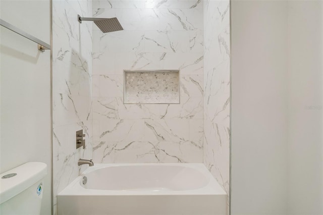 bathroom with tiled shower / bath combo and toilet