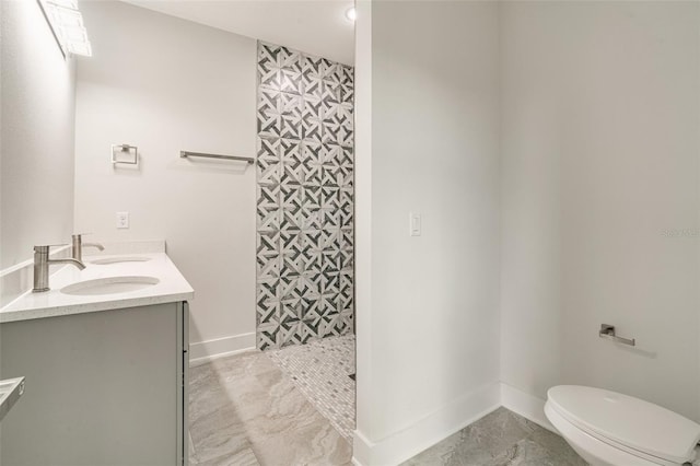 bathroom with walk in shower, vanity, and toilet