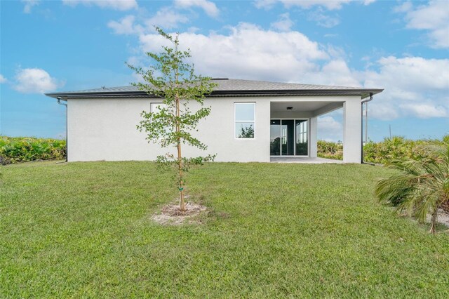 rear view of property with a yard