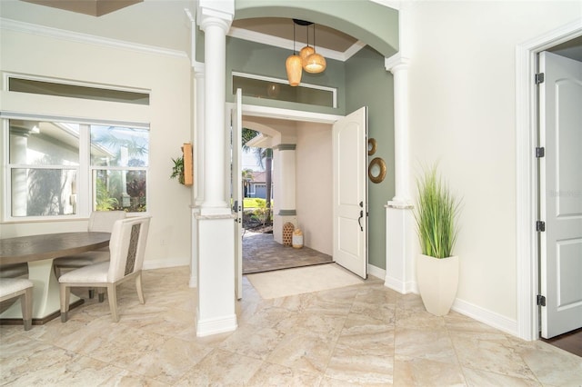 entrance foyer with ornamental molding and decorative columns