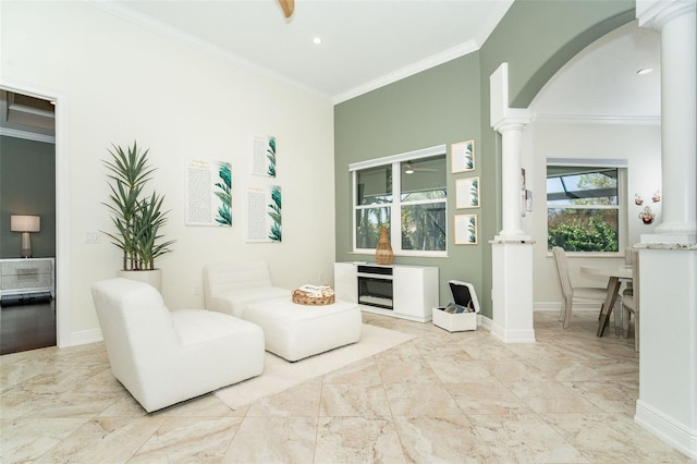 sitting room featuring ornamental molding, decorative columns, and ceiling fan