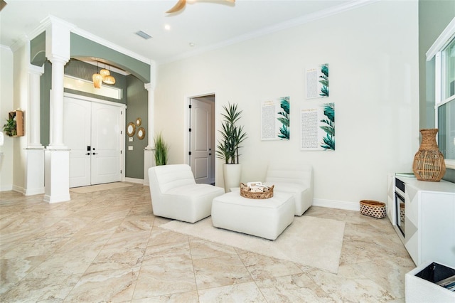 interior space with ornamental molding, decorative columns, and ceiling fan