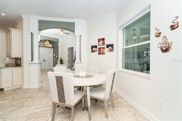 dining area with crown molding, ceiling fan, and ornate columns