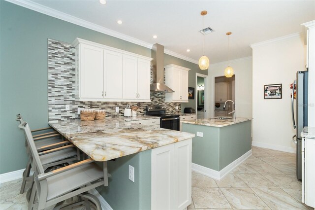 kitchen featuring white cabinetry, an island with sink, electric range, light stone countertops, and wall chimney range hood