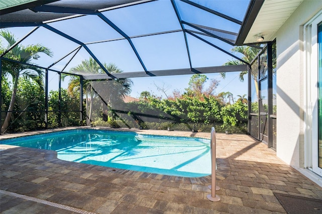 view of pool with a patio and glass enclosure