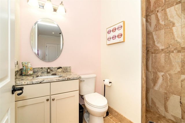 bathroom featuring vanity, tile patterned flooring, toilet, and tiled shower