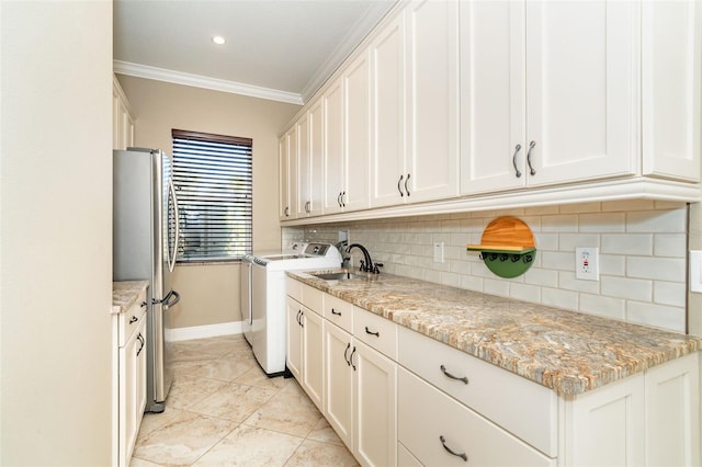 laundry room featuring sink, crown molding, cabinets, light tile patterned floors, and washer and clothes dryer