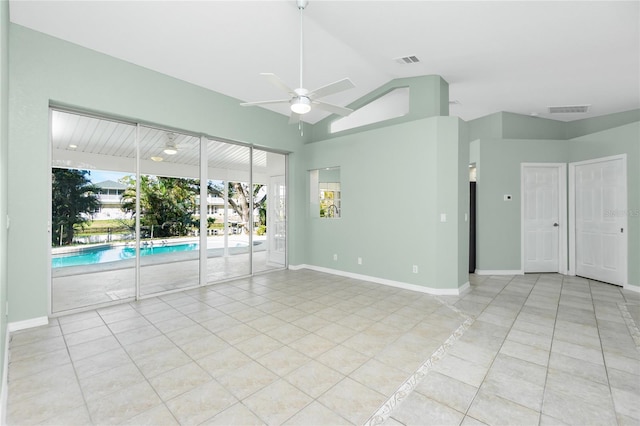 spare room with ceiling fan, light tile patterned floors, and vaulted ceiling