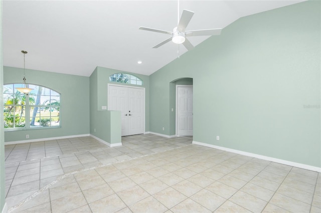 spare room with ceiling fan, lofted ceiling, and light tile patterned flooring