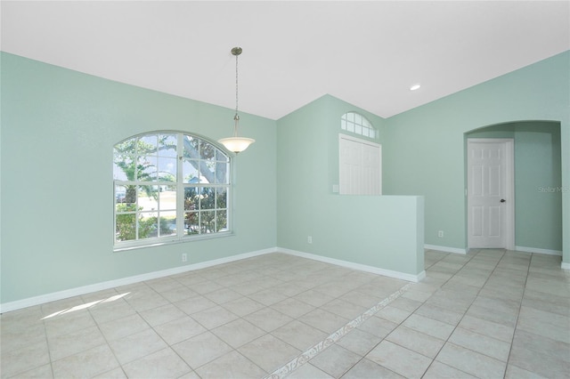 tiled spare room with lofted ceiling