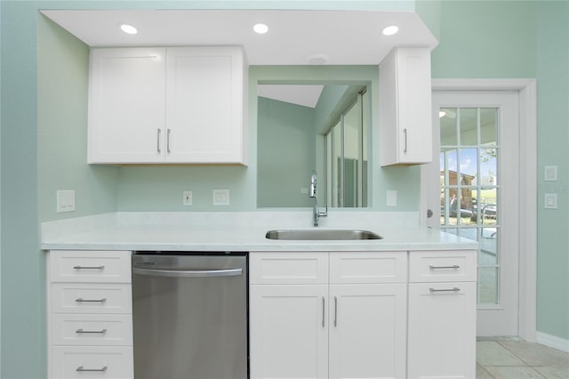 kitchen with white cabinets, dishwasher, light tile patterned floors, and sink