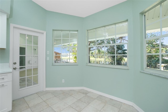 interior space with light tile patterned floors and a healthy amount of sunlight