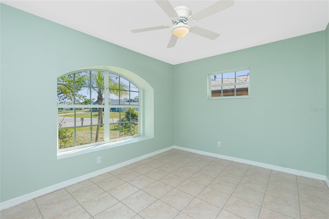 tiled empty room featuring ceiling fan