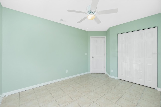 unfurnished bedroom with ceiling fan, a closet, and light tile patterned floors