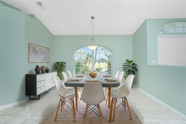 dining area featuring light tile patterned floors and vaulted ceiling