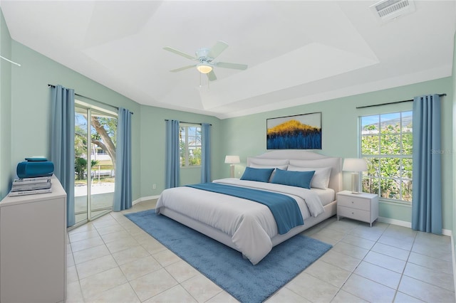 tiled bedroom with a raised ceiling, ceiling fan, and access to exterior