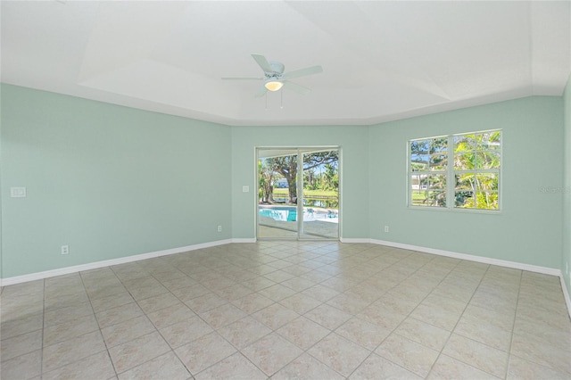 tiled empty room with a wealth of natural light and ceiling fan