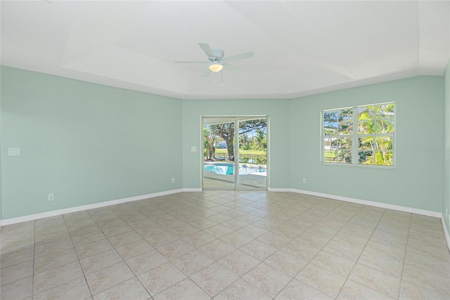 217 Rotonda Cir, Rotonda West, FL 33947 - unfurnished room featuring ceiling fan, a tray ceiling, and light tile patterned flooring
