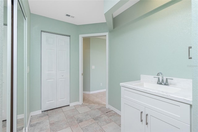 217 Rotonda Cir, Rotonda West, FL 33947 - bathroom featuring vanity, a closet, and stone finish floors