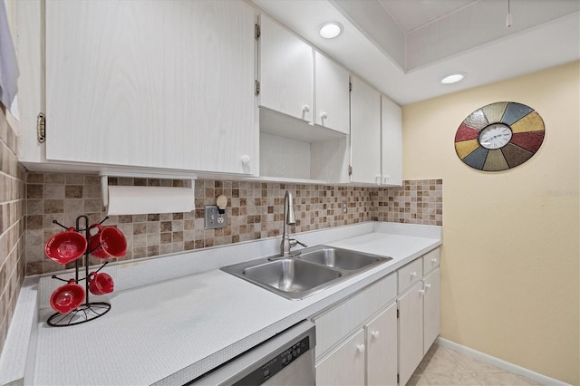 kitchen with dishwasher, sink, white cabinets, decorative backsplash, and light tile patterned floors