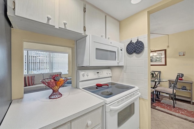 kitchen featuring light tile patterned floors, backsplash, and white appliances