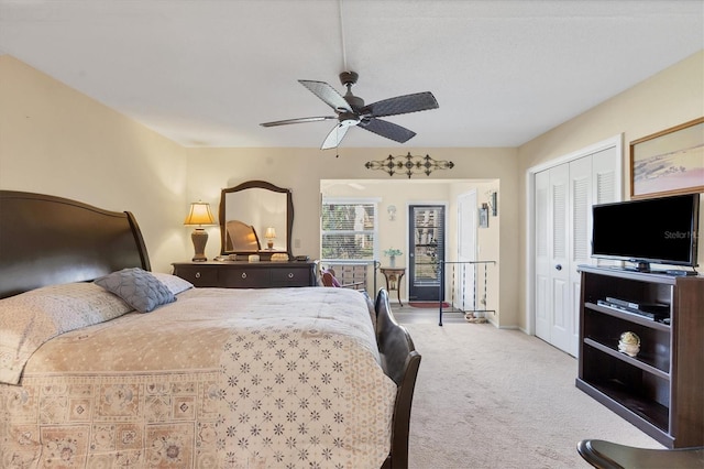 bedroom with a closet, ceiling fan, and light carpet