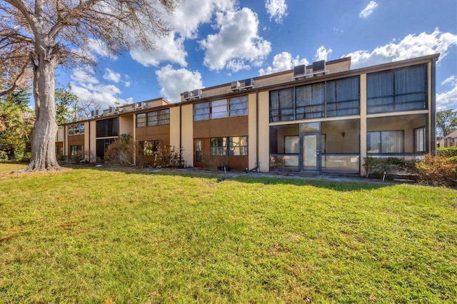 rear view of house featuring a lawn