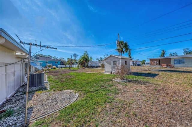 view of yard featuring central air condition unit and a storage shed