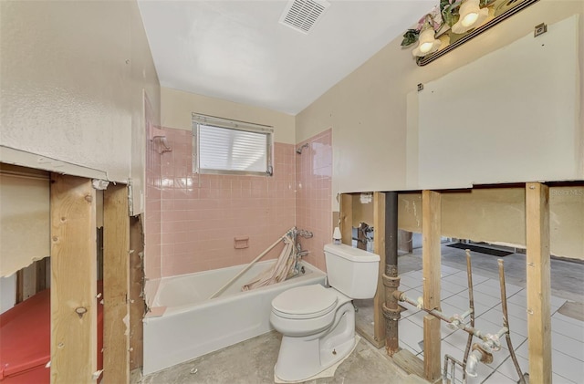 bathroom with toilet and tiled shower / bath combo