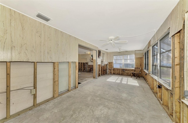 unfurnished sunroom featuring ceiling fan