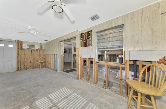 interior space featuring ceiling fan, wood walls, and a wall mounted AC