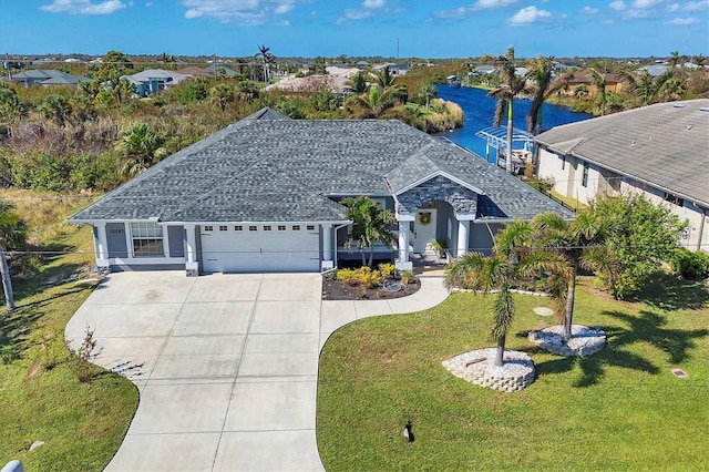 view of front facade with a garage, a water view, and a front yard