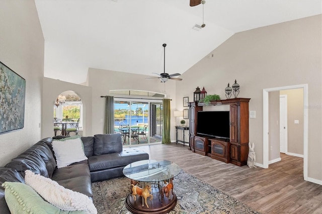 living room with ceiling fan, high vaulted ceiling, and wood-type flooring