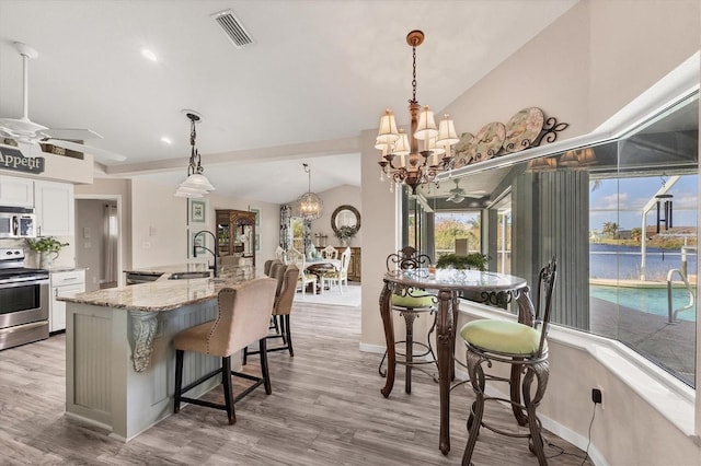 10083 Kansas City St, Port Charlotte, FL 33981 - kitchen with appliances with stainless steel finishes, a sink, a chandelier, ceiling fan, and light wood-style flooring