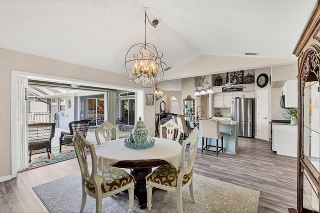 10083 Kansas City St, Port Charlotte, FL 33981 - dining area with a chandelier, lofted ceiling, and light wood-style floors