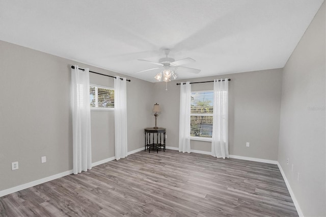 spare room featuring light hardwood / wood-style floors, a healthy amount of sunlight, and ceiling fan