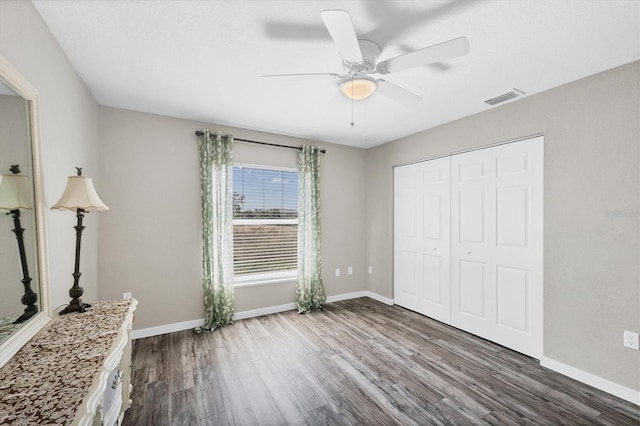 10083 Kansas City St, Port Charlotte, FL 33981 - unfurnished bedroom featuring dark wood finished floors, baseboards, a closet, and ceiling fan