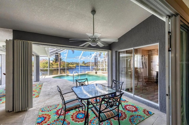 10083 Kansas City St, Port Charlotte, FL 33981 - dining room featuring a sunroom, a ceiling fan, a textured ceiling, a textured wall, and a water view