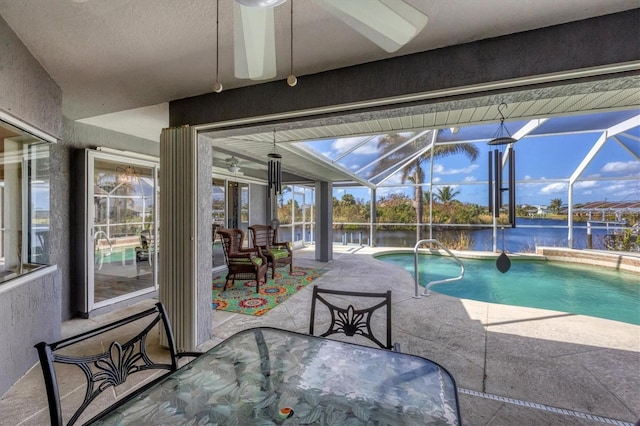 view of swimming pool featuring ceiling fan, a lanai, a patio, and a water view