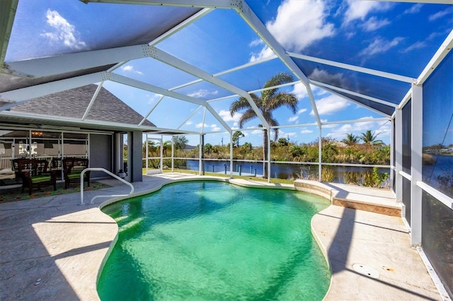 view of pool featuring glass enclosure, a patio area, and a water view