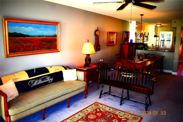 living room featuring sink, light colored carpet, and ceiling fan with notable chandelier