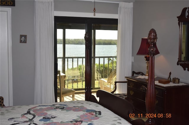 bedroom with access to outside and a water view