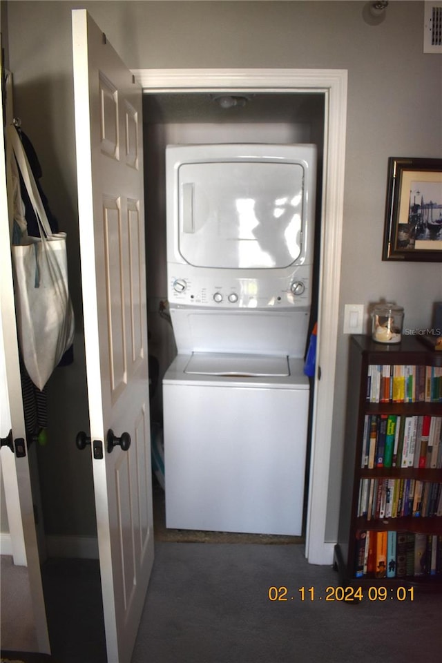 clothes washing area with stacked washer and clothes dryer