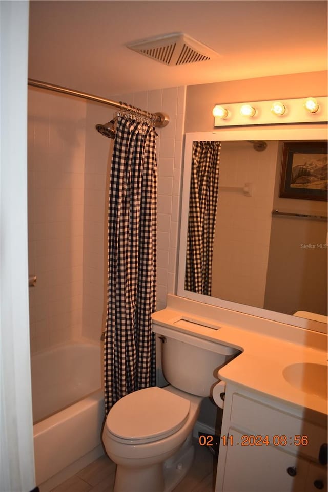 full bathroom with shower / bath combo with shower curtain, vanity, and toilet