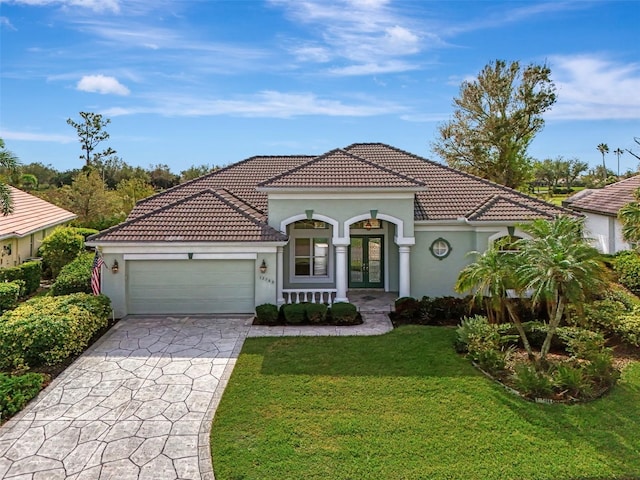 mediterranean / spanish-style house with a garage and a front lawn