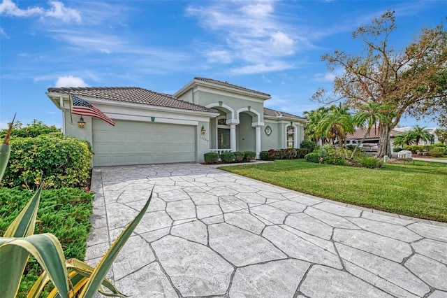 mediterranean / spanish home featuring a garage and a front lawn