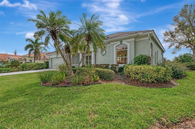 mediterranean / spanish-style house featuring a garage and a front lawn