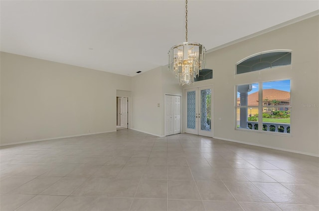 tiled spare room featuring high vaulted ceiling, french doors, and a notable chandelier