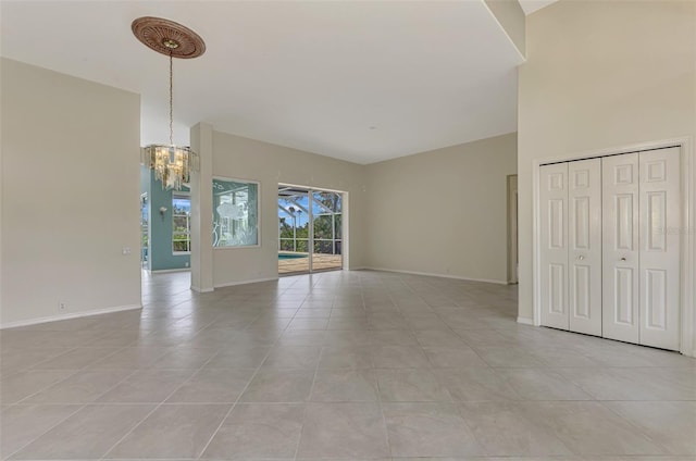 unfurnished living room featuring light tile patterned flooring and an inviting chandelier