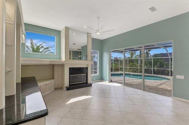 unfurnished living room with ceiling fan and light tile patterned floors